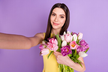 Self-portrait of attractive cheerful girl holding hugging tulips festal occasion isolated over violet purple pastel color background