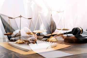 Justice and law concept.Male judge in a courtroom with the gavel, working with, computer and docking keyboard, eyeglasses, on table in morning light