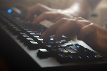 Man's hands are typing on the keyboard at home. Remote work of a programmer close up.