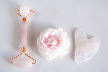 Pink Gua Sha stone and roller for massage and flower
