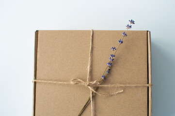 Blurred background. Craft paper box close up with lavender. Shipping eco package with flowers....