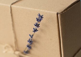 Blurred background. Craft paper box close up with lavender. Shipping eco package with flowers....