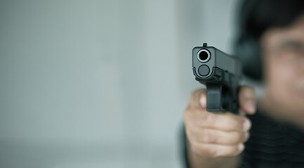Woman pointing a gun at the target. woman pointing a old gun to front with one Hand on dark...