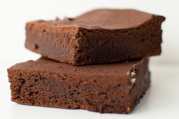 Pieces of fresh home-made brownie on white background. Delicious chocolate pie close-up isolated...