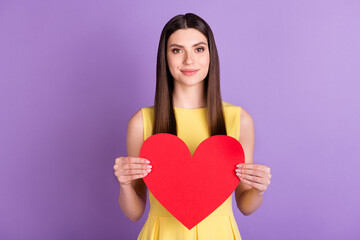 Portrait of attractive cheerful girl holding in hands large heart isolated over violet purple pastel color background