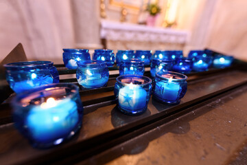Lumini votivi e candele per l'altare di una chiesa, preghiere dei fedeli e dei penitenti di tutte...