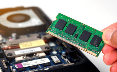 A man installed a new RAM memory chip into a laptop. Repair and upgrade concept of laptop.