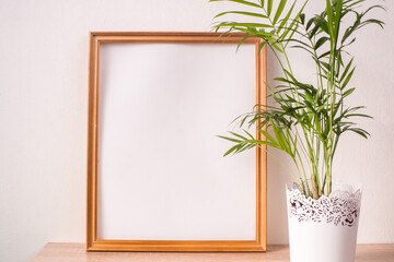 Portrait broun picture frame mockup on wooden table. White wall background. Scandinavian interior. 