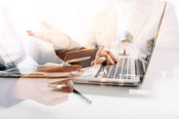 Fototapeta premium businesswoman hand using smart phone, tablet payments and holding credit card online shopping, omni channel, digital tablet docking keyboard computer at office in sun light