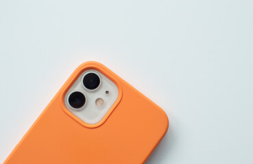 Close-up camera smartphone on white Background in orange case. Quick charge phone 12. Lightning, illustration for business.