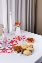 Beautiful Novruz table set up with national pastry in white plate with dyed red eggs and flowers in red and white colors. Celebration of spring equinox in Azerbaijan in March. Flat lay  copy space