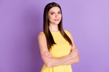 Obraz premium Portrait of attractive cheerful girl wearing yellow blouse folded arms isolated over violet purple pastel color background