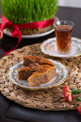 Novruz pastry pakhlava, Azerbaijan national holiday, ethnic cuisine eastern desserts for spring equinox celebration in white and golden plate. Persian nooruz sweets, copy space   