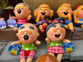 Laughing asian chidren clay figurine in the garden bangkok Thailand.