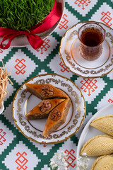 Novruz pastry pakhlava, Azerbaijan national holiday, ethnic cuisine eastern desserts for spring equinox celebration in white and golden plate. Persian nooruz sweets, copy space   