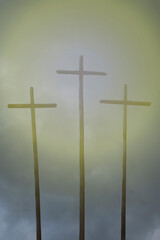 three crosses with glowing light on dark sky