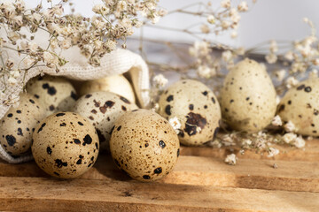 Obraz premium Quail eggs on burlap. Healthy food. Quail eggs lie on a wooden surface, selective focus. Rustic style. Easter concept