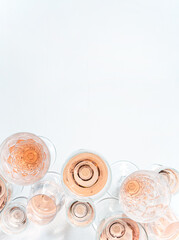 Sparkling rose wine in different glasses on white background with copy space