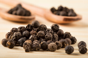 Pimenta do Reino. Black pepper on wooden background.