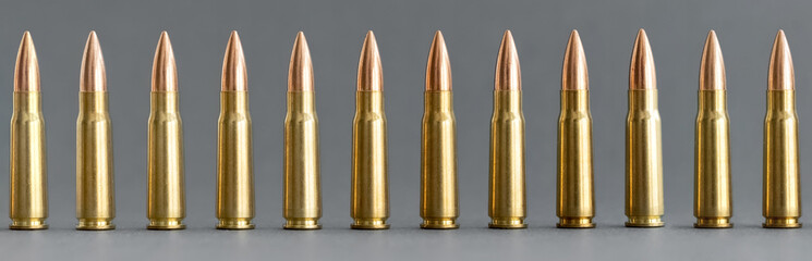Bullets on gray background. Cartridges 7.62 caliber for Kalashnikov assault rifle closeup,...