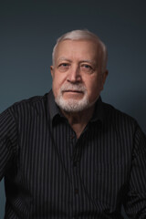 elderly handsome charismatic man sitting with glasses in hand and smiling, studio, dark background, portrait
