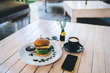 Table with yummy food and smartphone in cafe