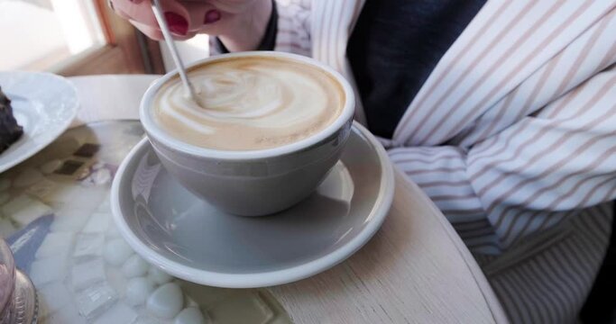 Person Hand Stirring Cup Hot coffee. Fresh Morning Coffee Close Up. reverse time