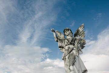 Statue of an angel and clouds in the sky
