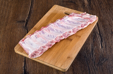Raw pork ribs on a wooden cutting board.