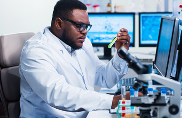 Professional African-American scientist is working on a vaccine in a modern scientific research laboratory. Genetic engineer workplace. Future technology and science.