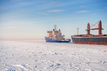 Big cargo ships in frozen ice sea fairway .