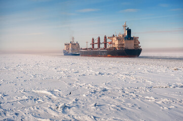 Big cargo ships in frozen ice sea fairway