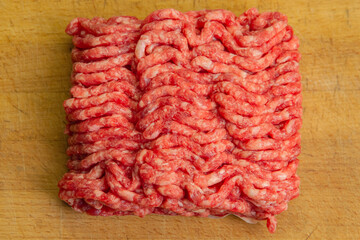 Red minced beef with chunks of fat on a chopping board