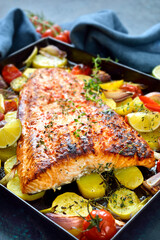 Großes saftiges Lachsfilet mit pikanter Chili-Honig-Marinade, mit Gemüse gebacken und heiß auf dem Backblech serviert - Juicy salmon fillet with a chili honey marinade baked with vegetables