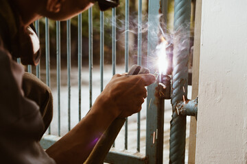 Portrait of workers welding iron fences