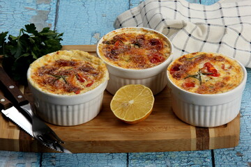 Cod casserole with cheese, sour cream and tomatoes. White fish casserole with cheese and sour cream, Baked fish on pot. Julienne of seafood