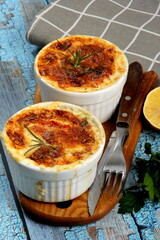 Cod casserole with cheese, sour cream and tomatoes. White fish casserole with cheese and sour cream, Baked fish on pot. Julienne of seafood