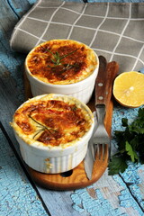 Cod casserole with cheese, sour cream and tomatoes. White fish casserole with cheese and sour cream, Baked fish on pot. Julienne of seafood