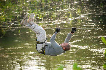 Army soldier conducts the rope bridge water crossing exercise. Water survival training