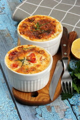 Cod casserole with cheese, sour cream and tomatoes. White fish casserole with cheese and sour cream, Baked fish on pot. Julienne of seafood