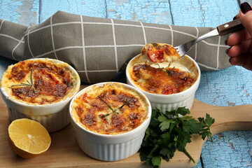Cod casserole with cheese, sour cream and tomatoes. White fish casserole with cheese and sour cream, Baked fish on pot. Julienne of seafood