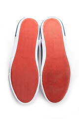 red sole of classic sneakers on white background with copy space. top view