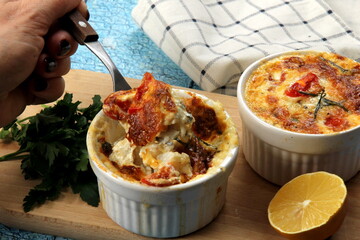 Cod casserole with cheese, sour cream and tomatoes. White fish casserole with cheese and sour cream, Baked fish on pot. Julienne of seafood