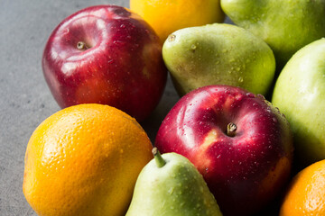 Organic fruits close up photo. Fresh juicy apples and pears on a table. Water drops on fa fruit skin. Healthy eating concept. 