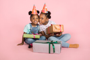 Holiday present, child's birthday concept. Two cute little excited african girls, wearing party...