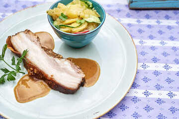 Schweinebauch Braten mit Kartoffelsalat im Biergarten