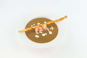 Cream soup with crab meat and bread stick on white background