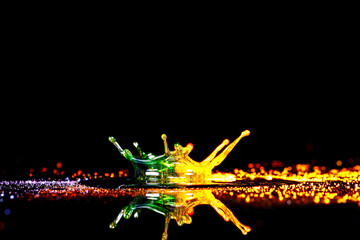 Drops of water colliding with powdered dye to create a multi coloured abstract droplet collision