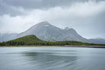Storm clouds gathering around mountain near lake, shot at Upper Kananaskis Lake, Alberta, Canada