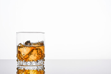 Whiskey with ice or brandy in glass with cigar on white background. Whisky with ice in glass. Whiskey or brandy. Selective focus.